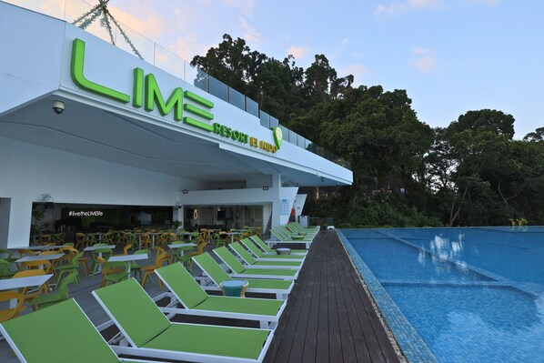 A resort with a poolside lounge area, outdoor seating, and a sign reading 'LIME RESORT ENJOY'. - Lime Resort El Nido (El Nido)
