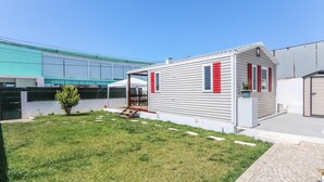 Ein kleines, eingeschossiges Haus mit Veranda und einer kleinen Terrasse.