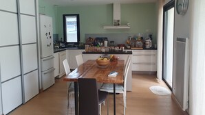 Una cocina moderna con una mesa de comedor, sillas y un refrigerador.