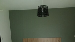 Un dormitorio con dos camas, cabeceros de madera y una lámpara colgante.