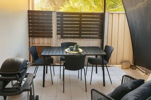 A patio with a table and chairs, a grill, and a covered area. - Urban Getaway Whole Home - 6BR/5BA, Sauna, Ipswich (Newtown)