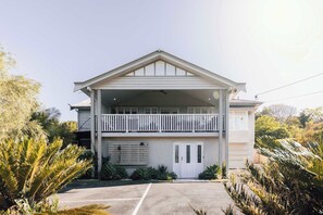 A two-story building with a balcony, a garage, and a driveway. - Urban Getaway Whole Home - 6BR/5BA, Sauna, Ipswich (Newtown)