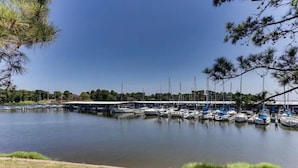 Un puerto deportivo con barcos amarrados, un paseo techado y cielo despejado.