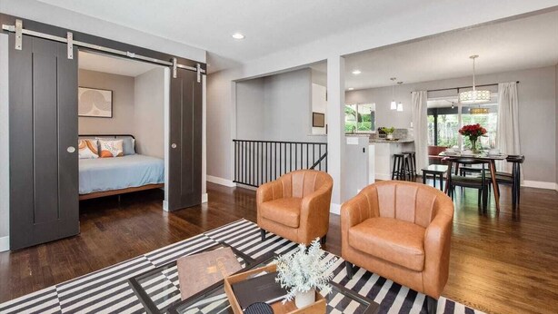 A modern living room with a sofa, a coffee table, and a dining area with a table and chairs.