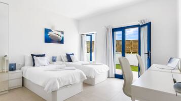 Une chambre moderne avec deux lits, un bureau et un ordinateur portable.