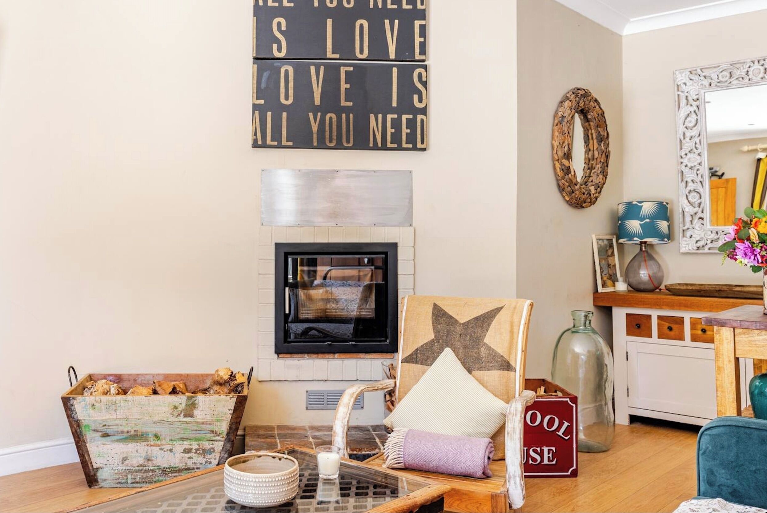 Un salon chaleureux avec une cheminée, un panneau décoratif et des meubles de style rustique.
