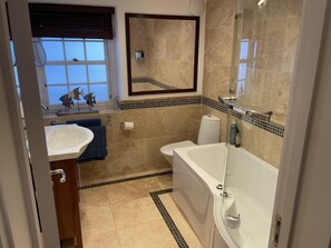 Ein modernes Badezimmer mit Badewanne, Toilette und Waschbecken.