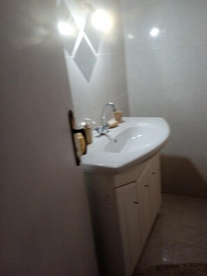 A bathroom with a white sink, a mirror, and a towel rack. - Studio Flat - Sleeps 4 & Private Garden (Sarandë)
