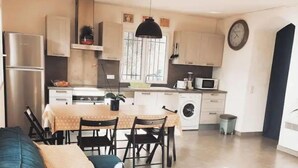 A compact living space with a sofa, dining table, and kitchenette. - Bas de Villa - Nice hinterland (Contes)