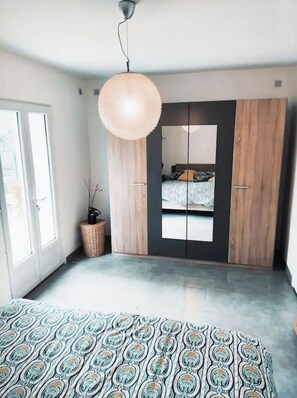 A bedroom with a bed, a wardrobe, a hanging light fixture, and a window. - Bas de Villa - Nice hinterland (Contes)