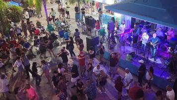 Un espacio al aire libre concurrido, con un escenario y asientos para un evento.