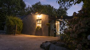 A building with a sloped roof, a front entrance with a glass door, and a small porch area. - Newly Renovated, Stylish Self-catering Apartment (Dawros)