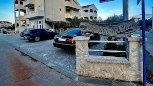 Una señal de calle indica 'Miroslava Krleže' y un letrero de madera anuncia 'PARIC APARTMANI'.