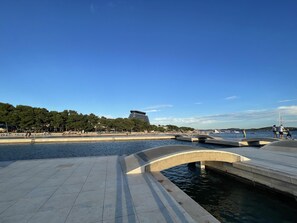 A waterfront promenade with a modern building, a bridge, and a clear sky. - Remarkable 1-bed Apartment in Vodice Croatia (Vodice)