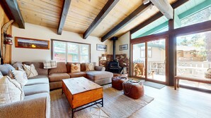 A cozy living room with a sofa, a wooden coffee table, and a fireplace.