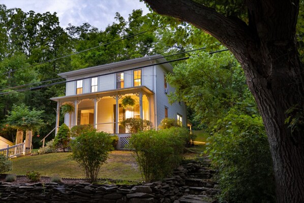Stunning two-story home with a charming porch and beautifully maintained garden.
