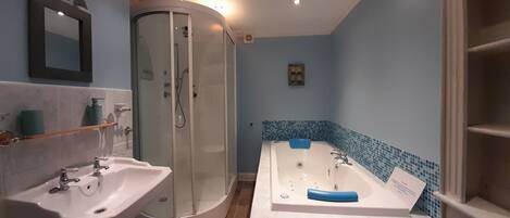 Une salle de bain avec une douche à parois de verre, un meuble-lavabo à deux vasques et une baignoire.