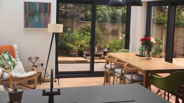 A modern kitchen with a dining area, large windows, and a view of the garden. - 5 Bed House - Sleeps 15 - Pets - Garden - Parking (Kingsbridge)