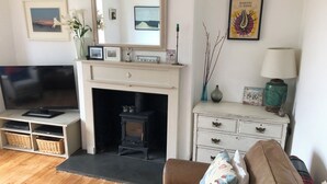 A living room with a television, fireplace, white dresser, and a sofa. - 5 Bed House - Sleeps 15 - Pets - Garden - Parking (Kingsbridge)