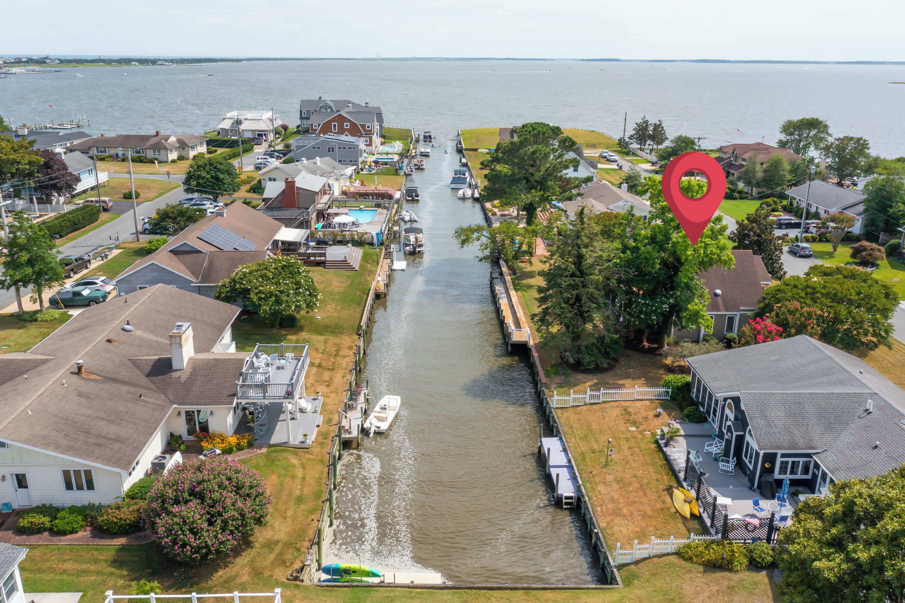 Una zona residencial con un canal, casas y un muelle para barcos.