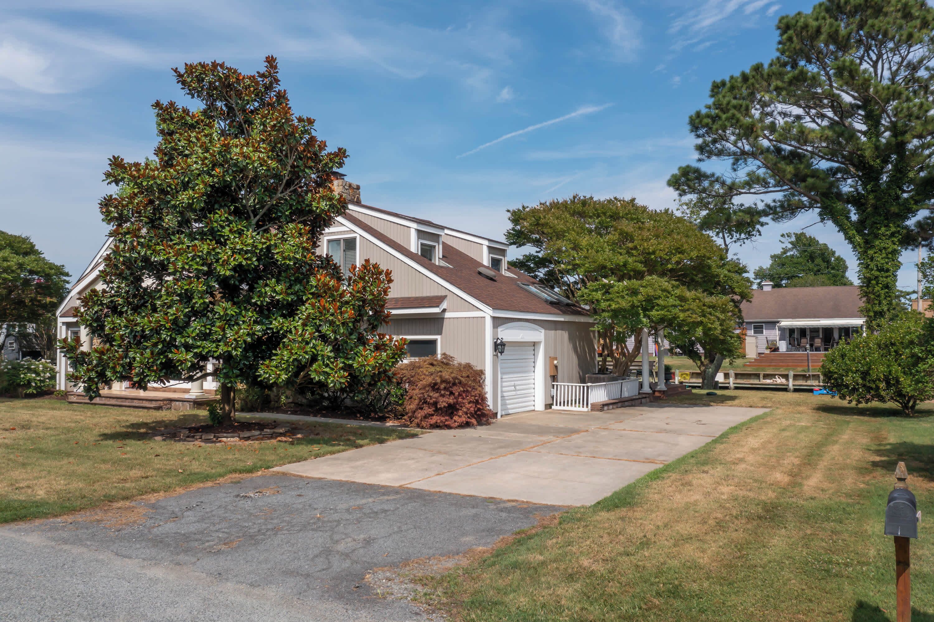 A two-story house with a front porch, a garage, and a driveway.