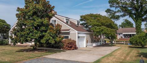 A two-story house with a front porch, a garage, and a driveway.