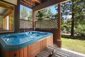 Relax in a hot tub surrounded by serene views of the surrounding trees and landscape.