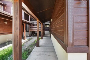 Corridors lead to a building with a balcony area, offering a simple, functional design.