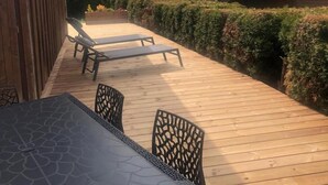 A wooden deck with a table and chairs, overlooking a mountainous landscape. - Chalet, Ground floor, parking, tv, ski locker, 44m², Le Grand Bornand (Le Grand-Bornand)