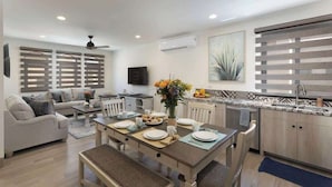 Una sala moderna con comedor, cocina y ventilador de techo.