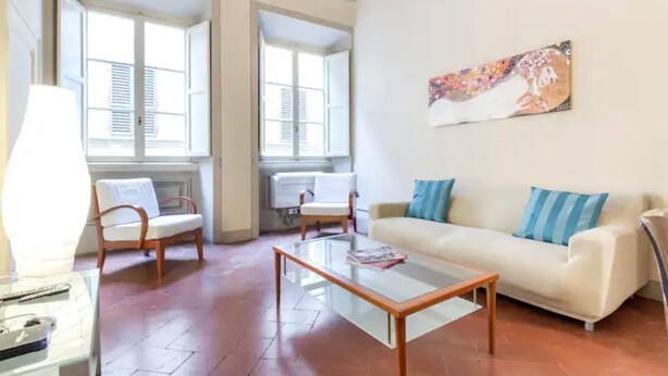 A living room with a sofa, two chairs, a coffee table, and a painting on the wall. - Reinassance Beauty - elegant apartment in the heart of Florence (Firenze)
