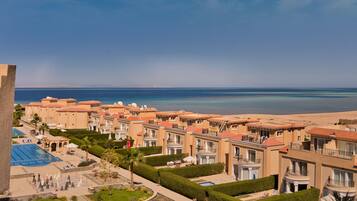 Un resort con varias construcciones, una piscina y vistas a la playa.