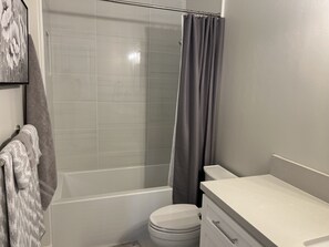 A bathroom with a shower, toilet, and a towel rack. - Brand New  Carlsbad Suite Near  La Costa  Resort (Carlsbad)