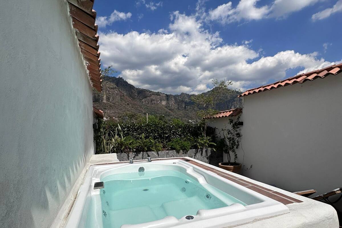 A hot tub in a courtyard with a mountain backdrop.