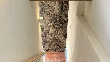 Una escalera con paredes de piedra y barandillas de madera.