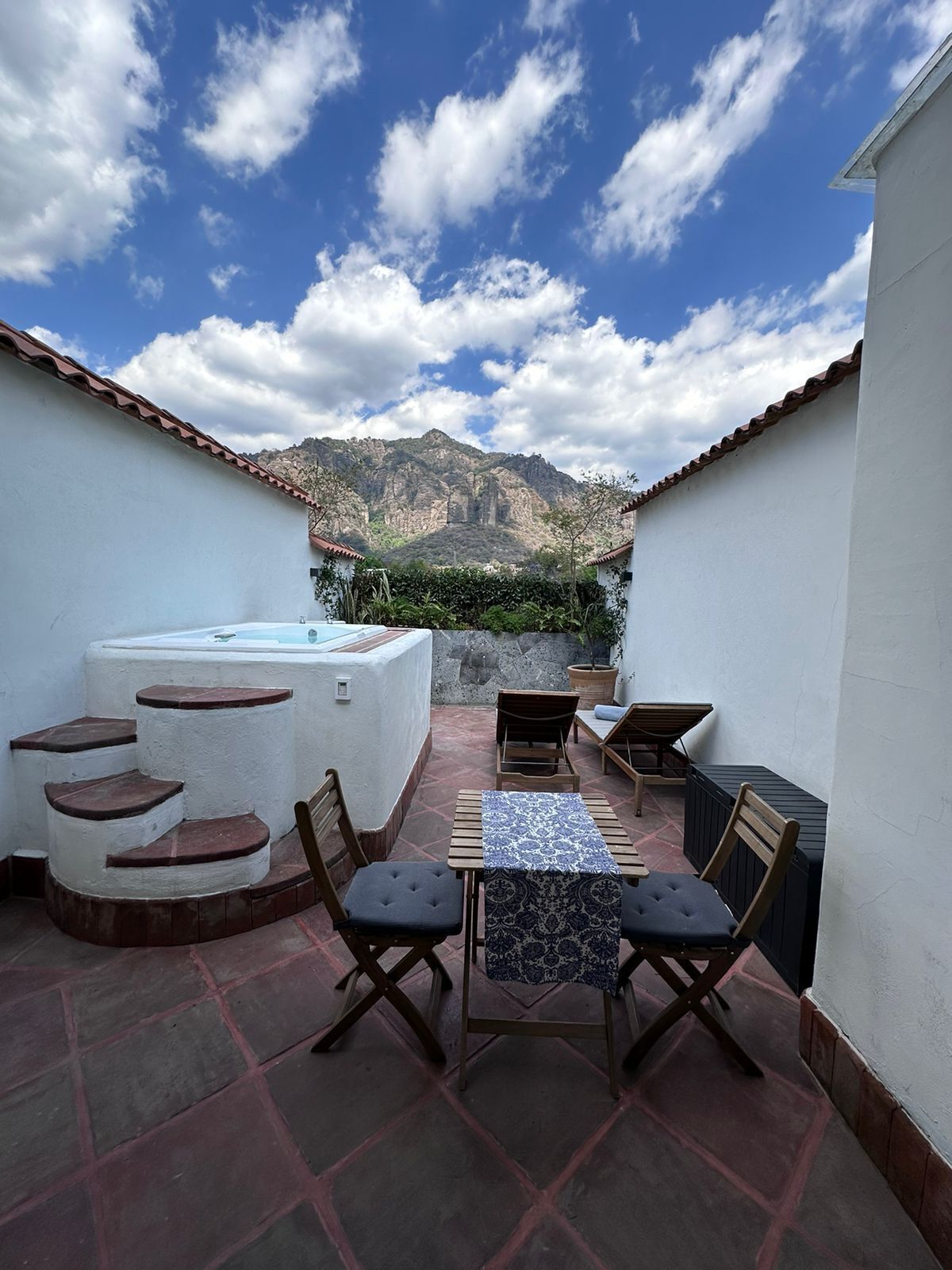 Une terrasse sur le toit avec un jacuzzi, des sièges d’extérieur et une vue sur les montagnes.