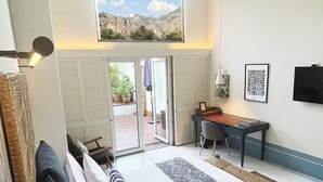 Un dormitorio con una cama grande, un escritorio y vistas al exterior.