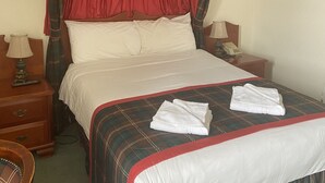 A neatly made bed with a red and green plaid canopy, white linens, and two folded white towels on the bed. - Lovat Arms Hotel (Beauly)