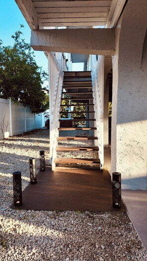 A staircase leading to a building entrance, surrounded by gravel and decorative lanterns. - Canal-Front Keys Retreat with Jacuzzi • Sleeps 12 (Big Pine Key)