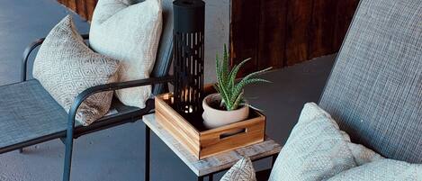 A seating area with a wooden crate containing a potted plant and a black vase.