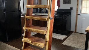 A wooden ladder in a kitchen with a refrigerator, stove, and cabinets. - Deadwood acres cabin #3 (Eminence)