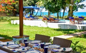 A table set for dining with blue and white plates, glasses, and cutlery. - Tamarind Tree Beachfront bungalow with pool (Zanzibar)