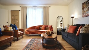 Un salon comprenant un canapé, des fauteuils, une table basse et un tapis.