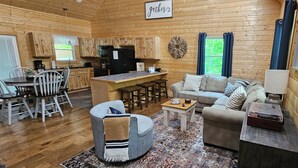 A cozy cabin interior with a kitchen, dining area, and living room. - Sugar Bear Cabin 5 mins from State Park!  Fishing, w/boat parking, golf & more! (Burkesville)