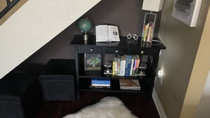 Una oficina en casa con un escritorio, libros, un globo terráqueo y una lámpara.