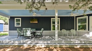 A covered patio with a table and chairs, a ceiling fan, and a view of the backyard. - Spacious 4BR/3BA with bunkhouse; perfect for family and friends! (Bryan)