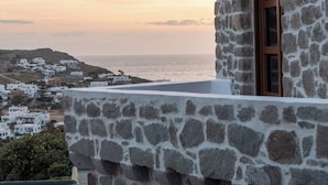 A stone building with a window and a view of the sea and distant hills. - Blue Vista Patmos Villa Margarita without the studios (Patmos)