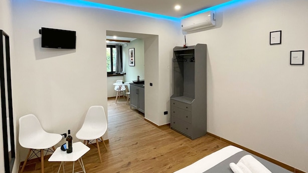 A modern hotel room with a bed, a TV, a desk, and a chair. - 1 Bedroom Apartment in Pozzuoli (Pozzuoli)