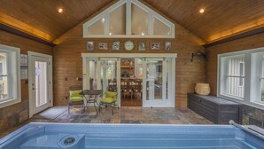 A wooden interior with a pool, seating area, and a dining space.