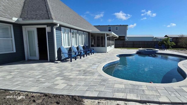 Ein Garten mit Swimmingpool, einer überdachten Terrasse mit Stühlen und einem Haus im Hintergrund.